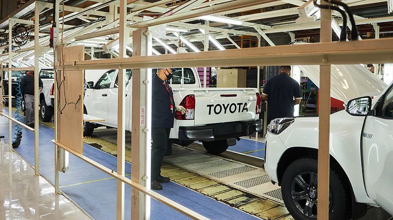 Workers inspect Hilux vehicles